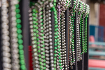 Plastic beaded necklaces haning on a rack.