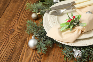 Beautiful Christmas table setting with mistletoe on wooden background. Closeup