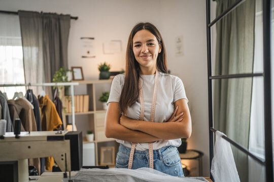 Adult woman tailor or fashion designer stand and work on sewing machine