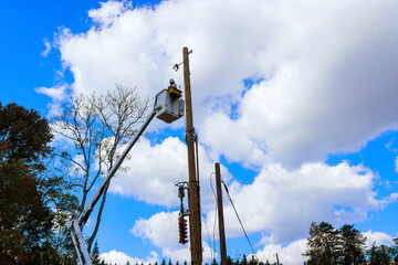 Electrician working repair at power line poles electric power system after hurricane using truck...