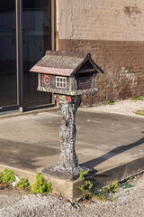A mailbox in the shape of a small house.