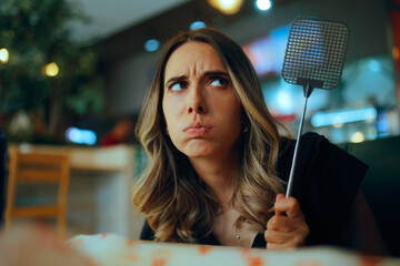 Fast Food Client with fly Swatter for Annoying insects. Customer upset in a diner infested with...