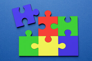 Obraz premium Many colorful puzzle pieces on blue background, top view. Symbol of autism