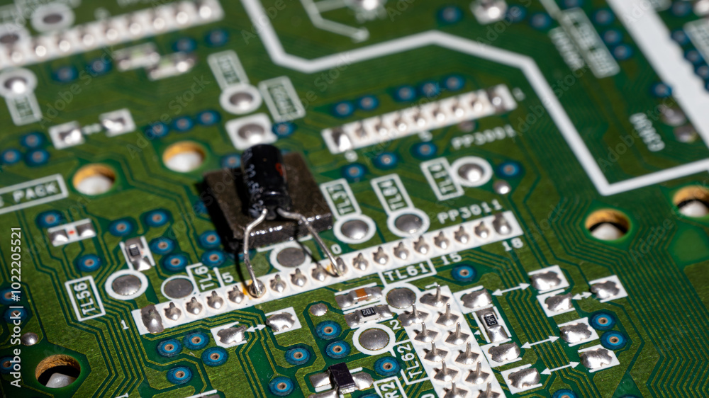 Poster a green circuit board with a black component on it