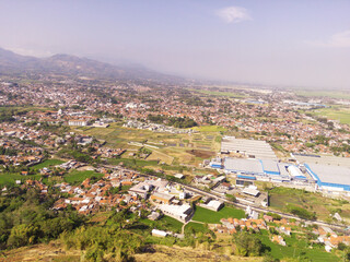 Factory Landscape under the hill from Aerial Perspective. The valley contains factories, roads and residential houses. Wallpapers Backgrounds. Natural Scenery. Aerial Photography Concepts