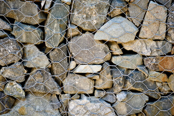 Gabion wall made of stones stacked in mesh wire