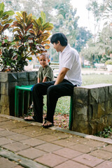 A father and his child sitting and chatting in a city square