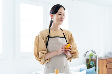 キッチンで野菜を持つ女性