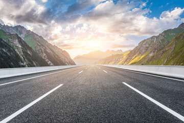Naklejka premium Asphalt highway road and green mountain nature landscape at sunrise. Road trip.