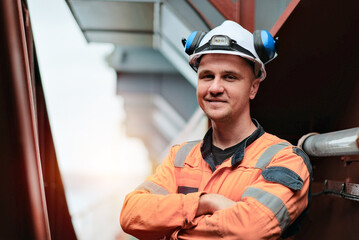 Portrait Of Smiling Technical Inspector Superintendent Offshore In Protective Personal Equipment 