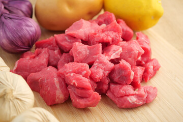 Delicious Fresh Raw Beef Chunks Combined with Colorful Vegetables Displayed on Wooden Surface