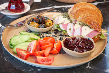 Savor a Delicious Breakfast Plate Featuring a Croissant, Fresh Fruits, and Various Dips