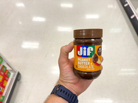 Holding a jar of Jif Peanut Butter Chocolate.