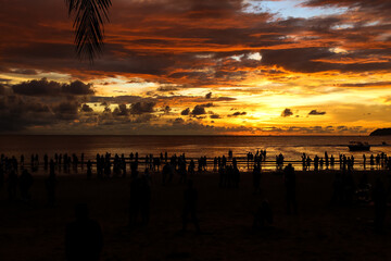 A silhouette of people at the beach during a beautiful sunset at Tanjung Aru Beach, Kota Kinabalu, Sabah, Malaysia