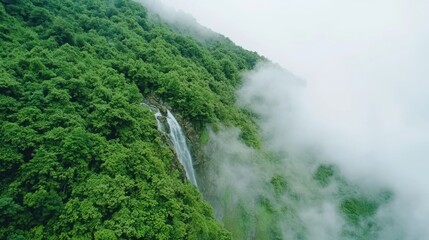 Majestic Cliffside Waterfall in Tropical Rainforest with Sunlight Breaking Through Clouds