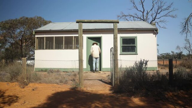 A man walks into a historic hut in the Australian outback.