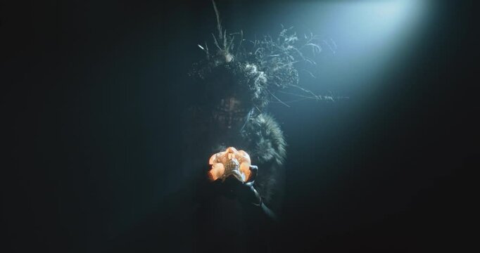 The witch rises a skull candle and cast a spell during the storm