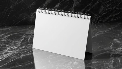 A blank tabletop calendar with a spiral binding, set against a dark marble background, ideal for notes or reminders.