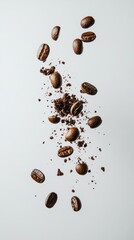 A collection of coffee beans and grounds scattered artistically on a white background.