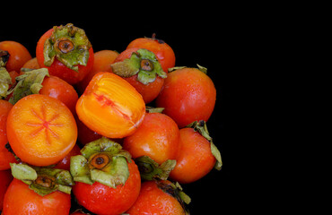 Persimmon fruits isolated on black background. Copy space for text.	
