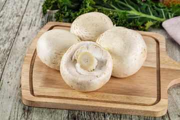 White champignon mushrooms heap over board