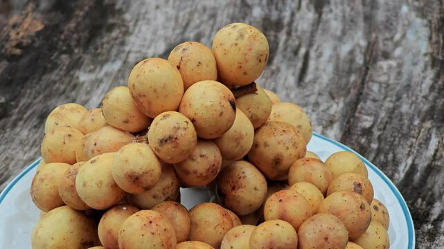 Longkong (Lansium domesticum) fruit on wooden table.
