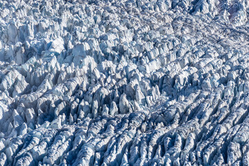 Highly textured glacial snow and ice with linear formations created by pressure and motion.