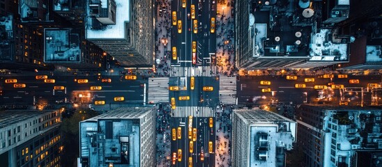 Aerial view of a city intersection at dusk with traffic moving in all directions, creating a grid pattern.