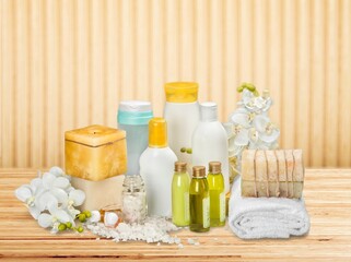 Spa cosmetic bottles with scrub on wooden background