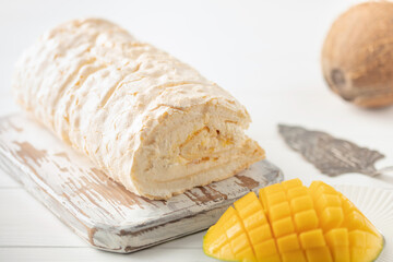 Homemade Meringue Cake Sweets Roll with Mango jam on wooden board.