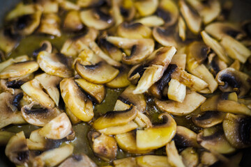 closeup view of roasting cut champignon mushrooms