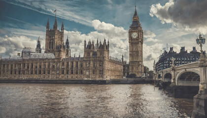 Fototapeta premium The iconic Houses of Parliament and Big Ben shining under a dramatic sky in London by the River Thames during late afternoon