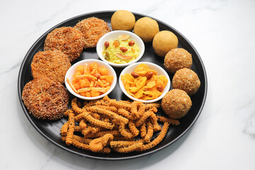 Indian festival food. Diwali Special sweet and salty snacks include Chakli, coconut laddu, besan ladu, poha and sabudana chivda, corn or maka mixture, Anarasa. Diwali Faral from Maharashtra, India.
