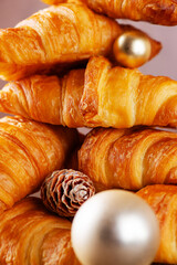 Christmas croissants with golden balls and cones, closeup. Vertical orientation.