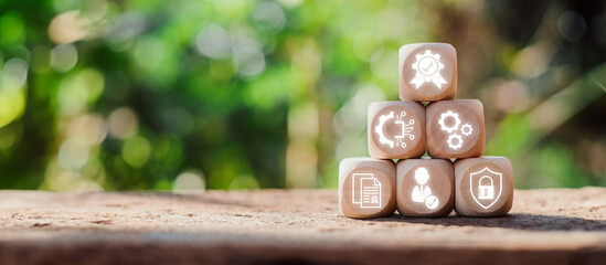 Wooden blocks with icons representing ISO 27001 information security management concepts on a...
