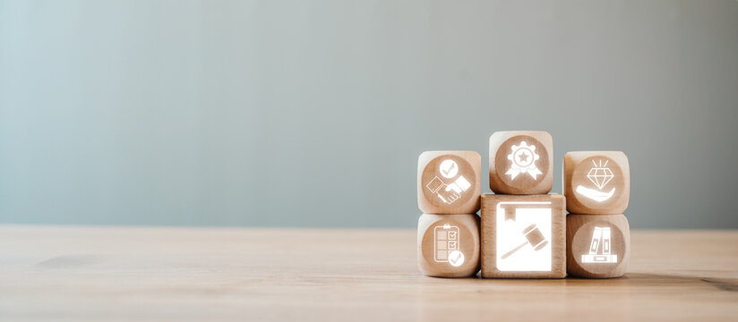 Wooden blocks with icons symbolizing ethics, rules, and standards, representing the concept of a code of conduct in a professional setting.