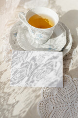 mockup of invitation against the background of a cup of tea with a saucer
