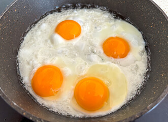 A pan of eggs is cooking on a stove