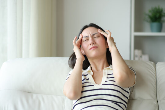 Asian woman suffering migraine at home