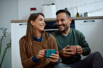Happy couple enjoying in cup of coffee while relaxing at home.