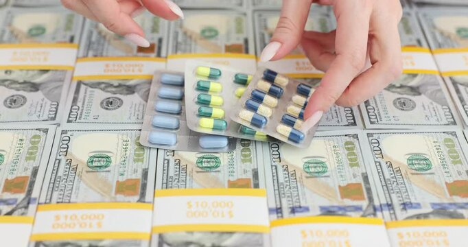 Hands place medical pills over stacks of US hundred dollar bills