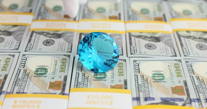Blue diamond on a stack of hundred dollar bills