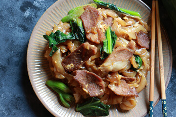 Stir fried rice noodle with soy sauce, pork meat, egg and Chinese Broccoli. Thai street food Pad See Ew