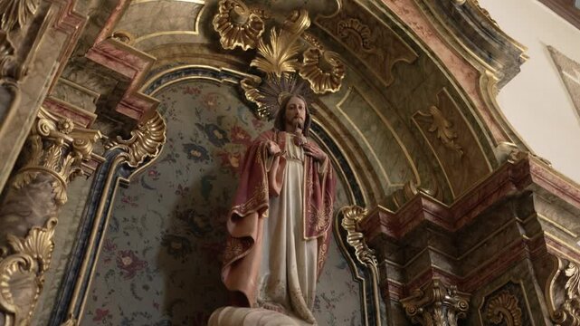 detailed statue of Jesus in an ornate church alcove, surrounded by intricate gold and marble accents