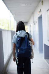 Obraz premium 秋の朝のマンションの廊下で歩いて登校する中学生の姿