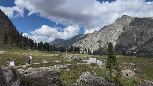 Time Lapse Serene Mountain Lake Landscape with Dramatic Clouds,Sunshine,Dark Skies, Featuring a Pictures que Valley,Green Meadows, and Traditional Huts, with Vehicles and People Enjoying Nature,4k