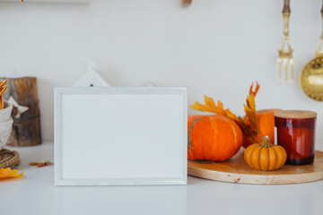 A cozy autumn setting with pumpkins, warm candles, and a blank frame ready for decoration