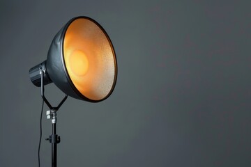 Studio lighting setup with a softbox illuminating a gray background in a photography studio