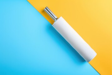 Lint roller resting on a vibrant blue and yellow backdrop