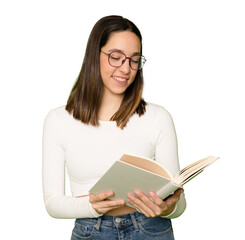 Smiling attractive beautiful pretty young brunette woman 20s wearing posing standing holding in hands reading book over transparent background.